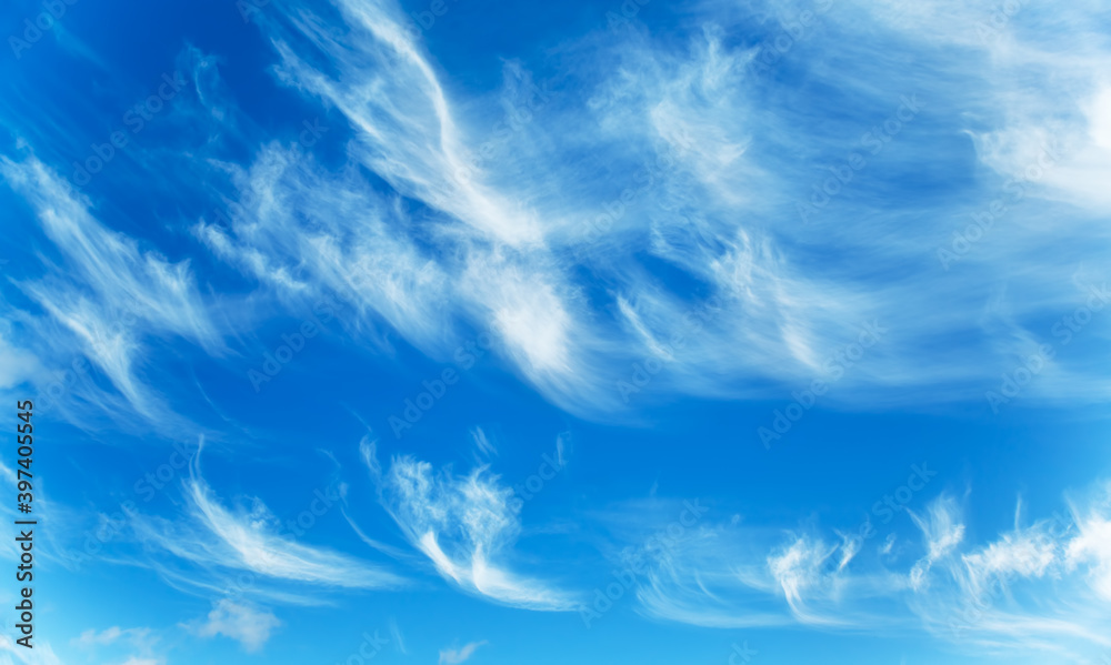 Sunny background, blue sky with white cirrus clouds 