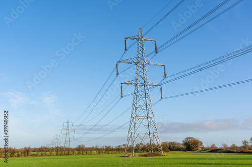 Electricity pylons in a field with blue sky. Bishop's Stortford, Hertfordshire. UK photo