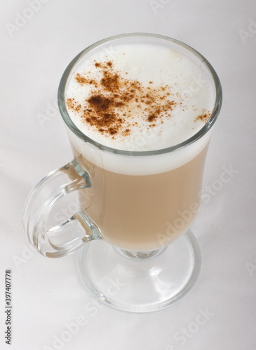 Cappuccino with cinnamon in a glass glass