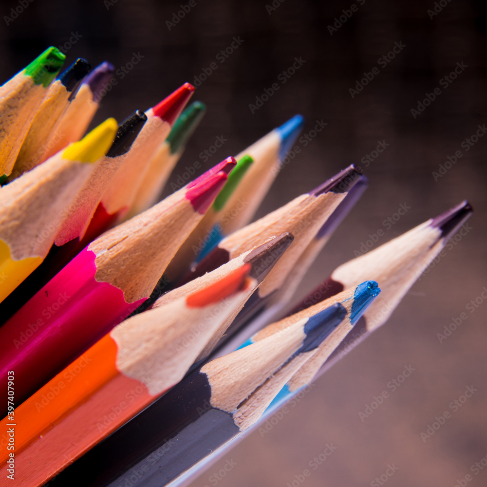 Colored pencils on a dark background stacked, close-up Colored pencils on a dark background stacked, close-up