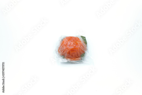 Red tortoise cake wrapped in plastic over white background