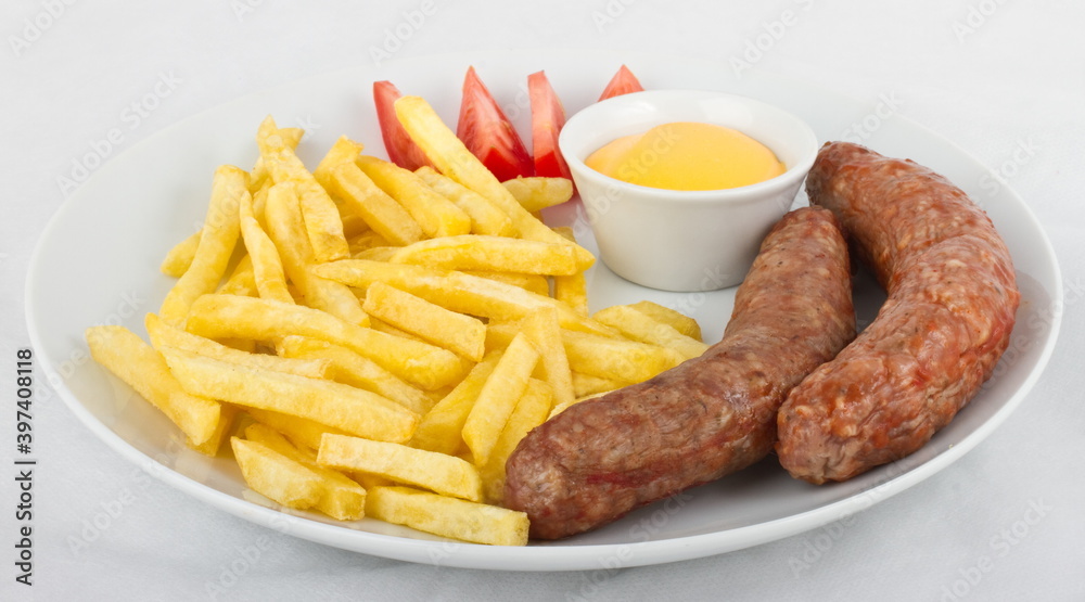 Veal sausage with French fries, tomatoes and cheese sauce Veal sausage with French fries, tomatoes and cheese sauce