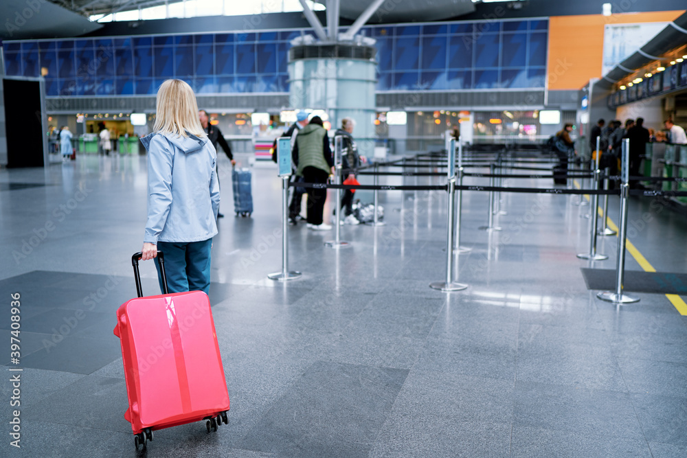 Traveling concept. Young woman in casual wear standing in international airport terminal. Traveling concept. Young woman in casual wear standing in international airport terminal.