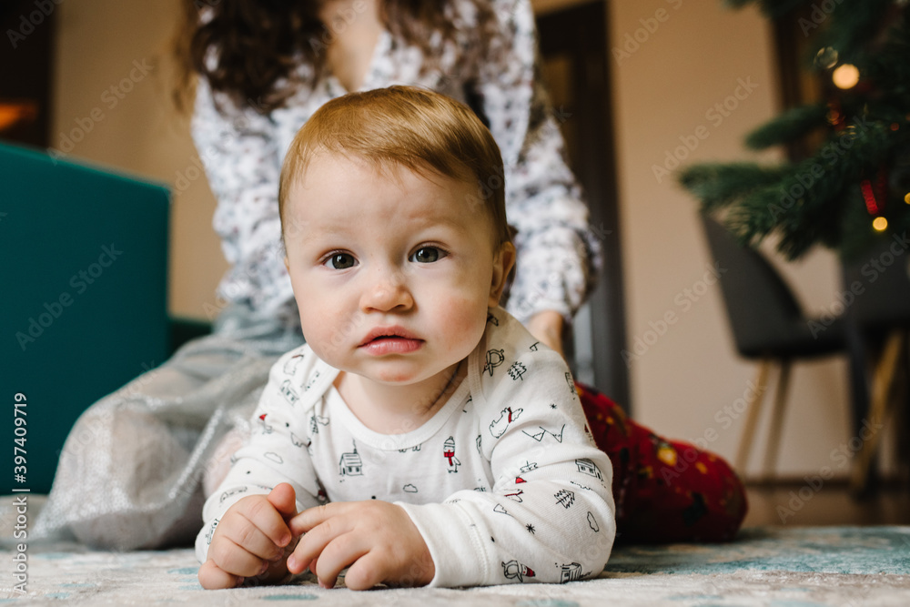 Mom plays with a little baby boy on the floor. Mother and son. Happy family weekend. Close up. Mom plays with a little baby boy on the floor. Mother and son. Happy family weekend. Close up.
