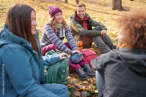 Holidays with friends. Group of young people sitting together in the park.