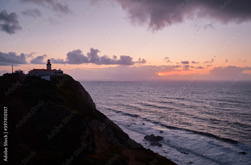 Famous lighthouse on Cabo da Roca, the western point of Europe. Beautiful sunset landscape with ocean shore.