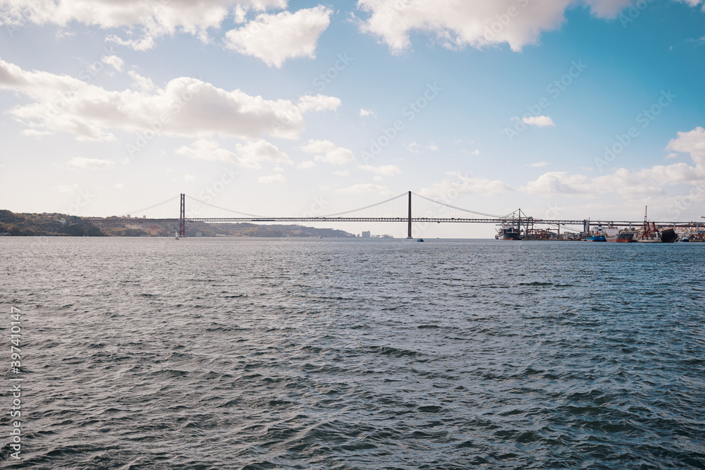 Naklejka premium Beautiful landscape with suspension 25 April bridge bridge over the Tagus river in Lisbon, Portugal.
