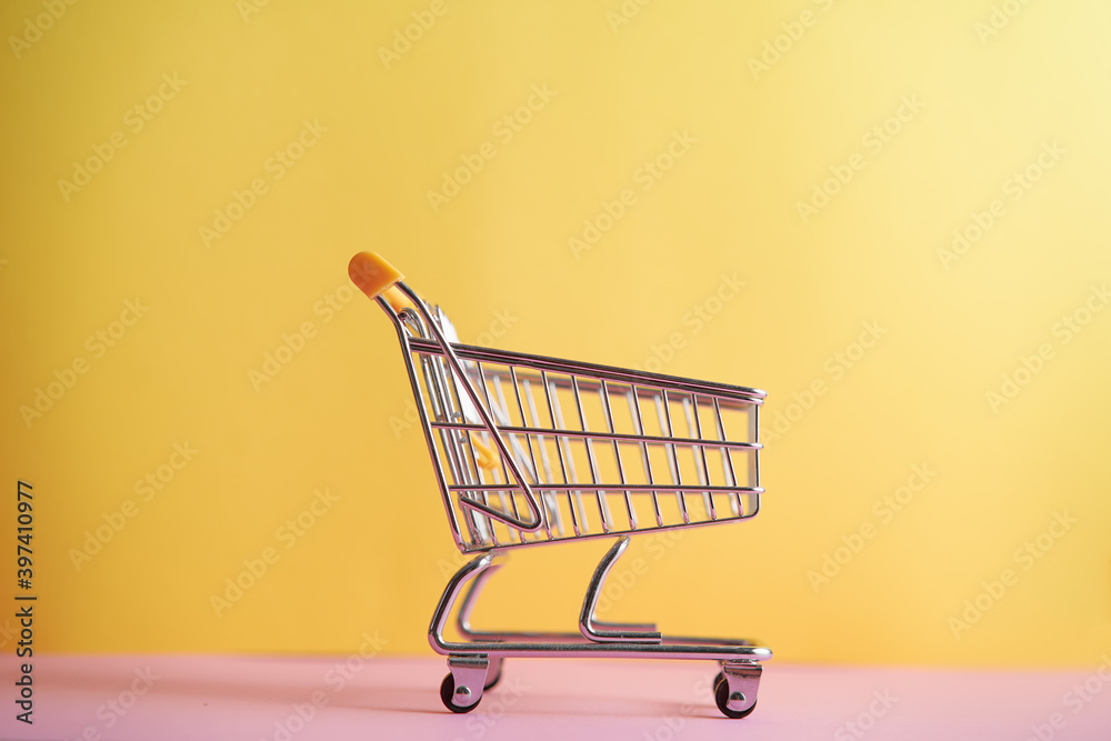 Mini shopping trolley for shopping on a colored background, consumer concept