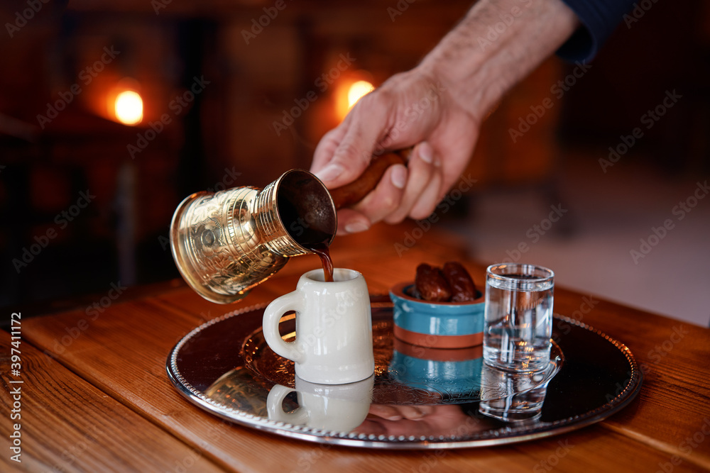 Traditional turkish coffee in cezve on metal tray.