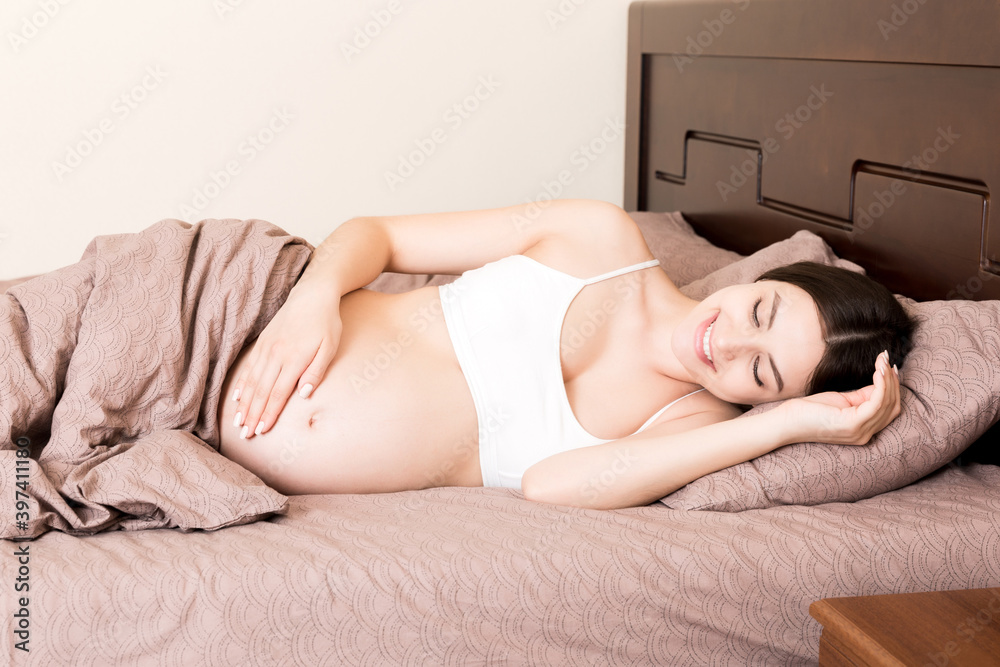 beautiful young pregnant woman lying in bed, top view. the girl suffers from the fact that her husband left her