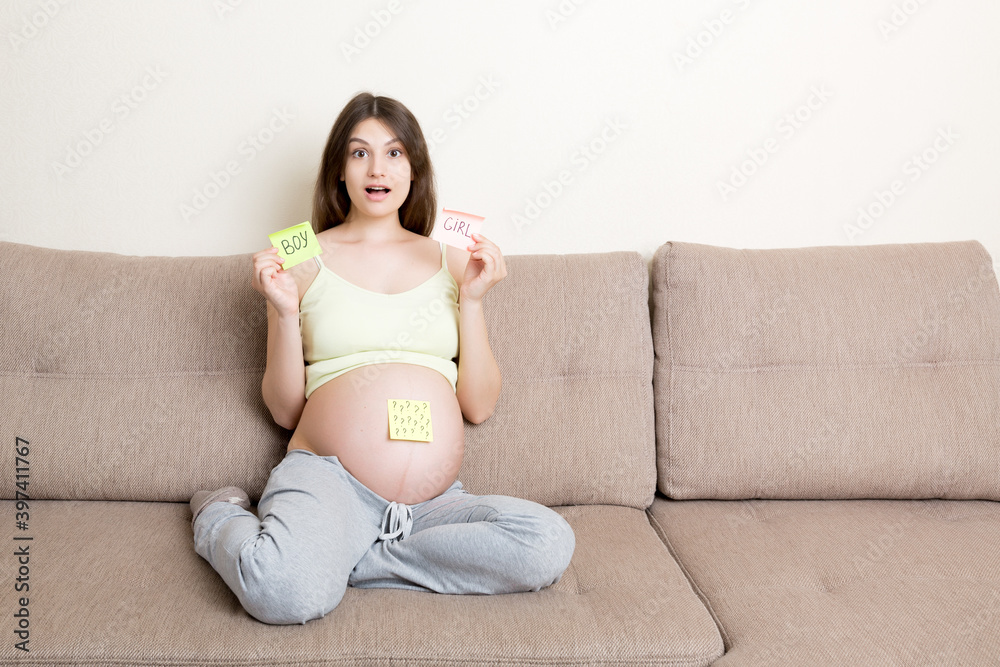 pregnant woman holding square multicolored stickers with question marks pregnant woman holding square multicolored stickers with question marks