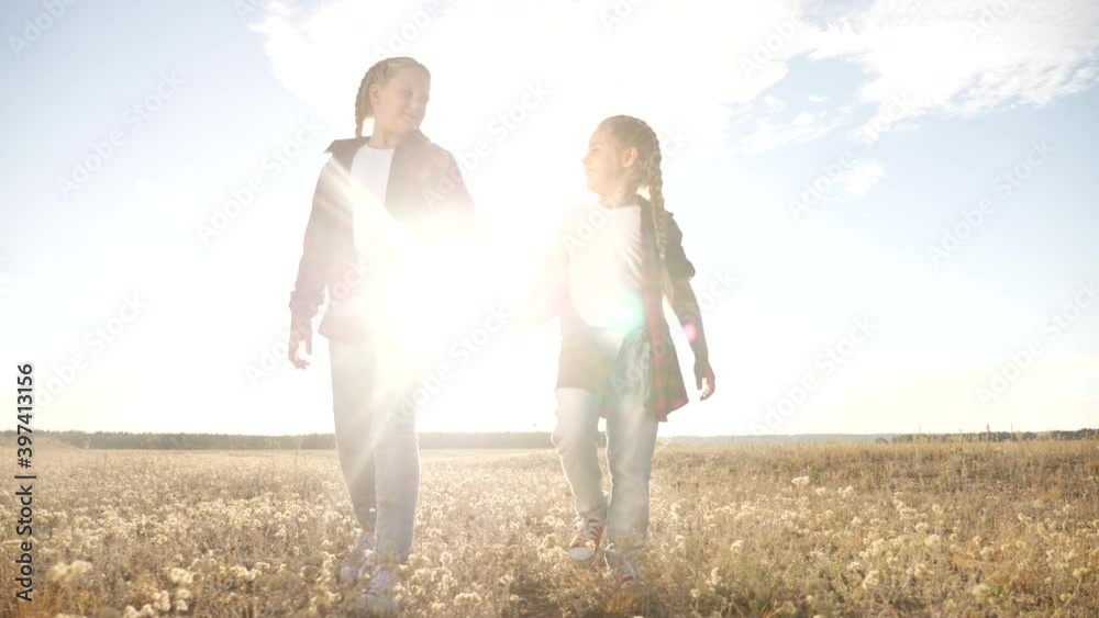 children walking in the park holding hands. kid dream happy family concept. children walking in nature outdoors sunlight. two sisters are walking together. kid with girlfriend fun holding hands dream children walking in the park holding hands. kid dream happy family concept. children walking in nature outdoors sunlight. two sisters are walking together. kid with girlfriend fun holding hands dream