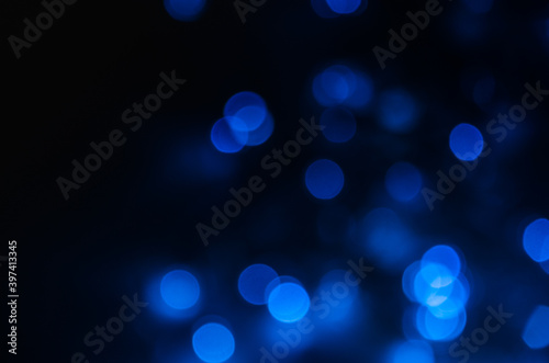Abstract pattern of blue bokeh lights on black background