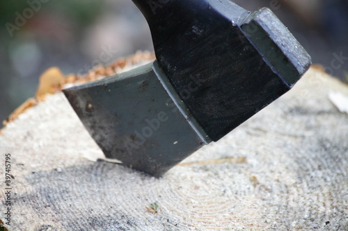 Modern axe blade in a log close-up, woodman equipment tool
