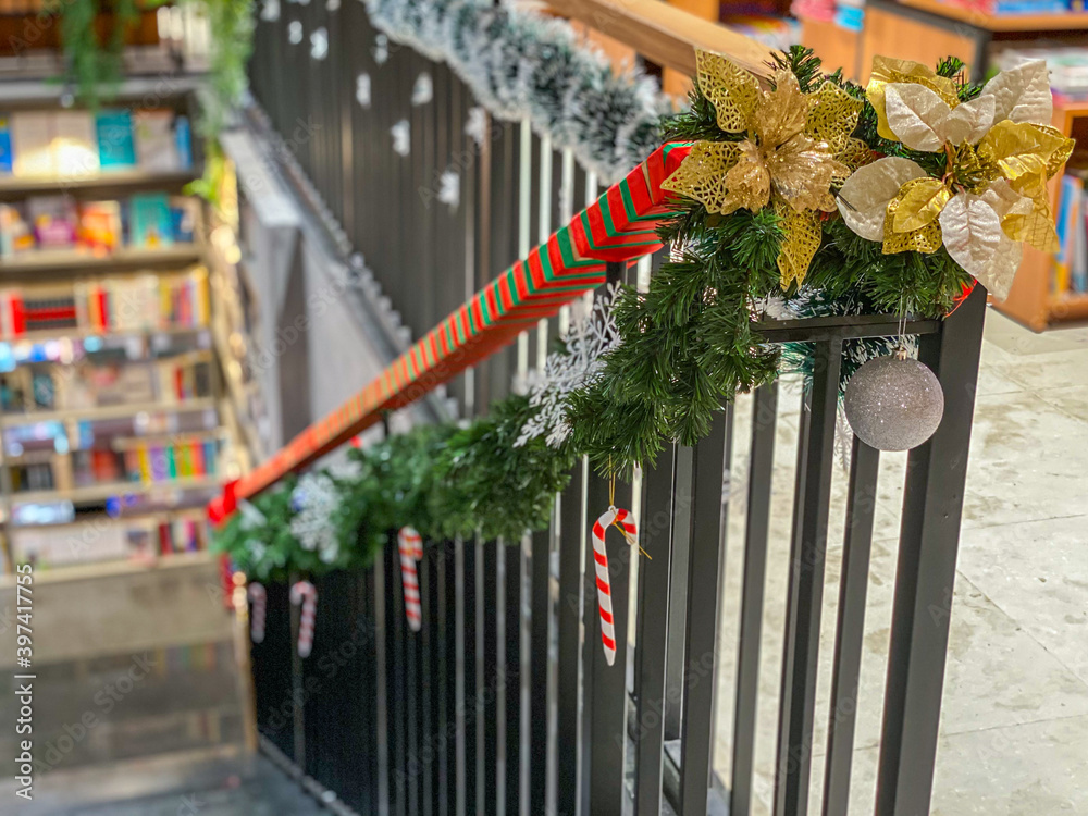 Obraz premium Stairs handrail with snowy garland and baubles for Christmas decoration