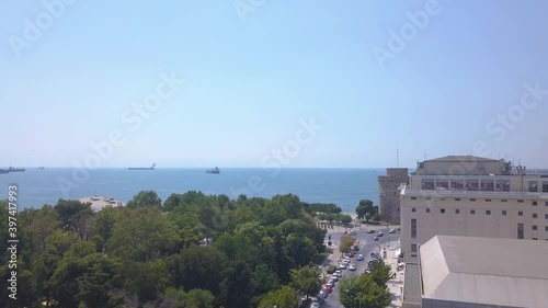 Unique aerial panoramic drone revealing shot of iconic white tower in Thessaloniki,