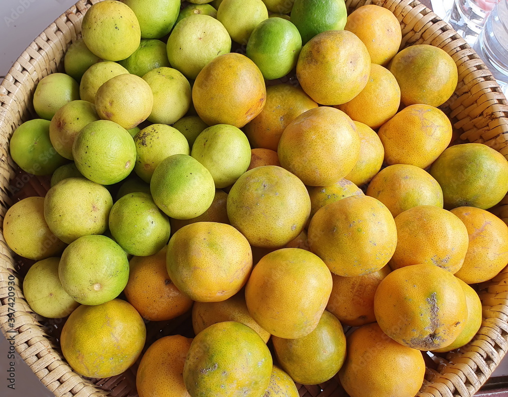 Organic Tangerine and lime are placed in a basket to produce fruit juices.Oranges have a sweet and sour taste and lemons have a sour taste.This fruit is high in vitamin C,which helps prevent colds 
