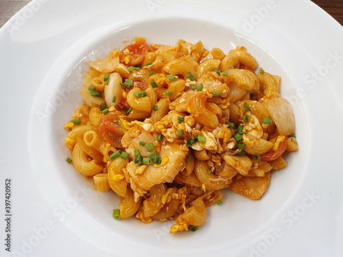 Stir fried macaroni with onion, pork and tomato sauce sprinkled with shredded green onions Served in a white plate, this is a popular Italian dish made with wheat flour, before cooking it must be boil