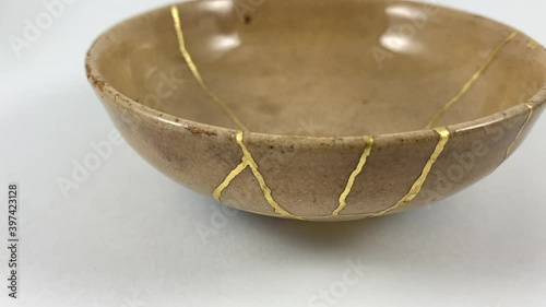 Antique broken Japanese beige bowl repaired with gold kintsugi technique