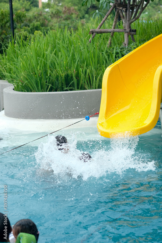 Excited boy having fun on water slide.