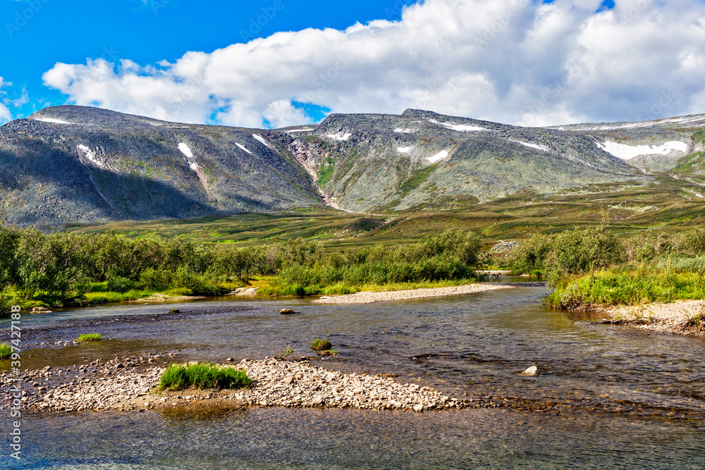 cold stream and mountain range on a summer day