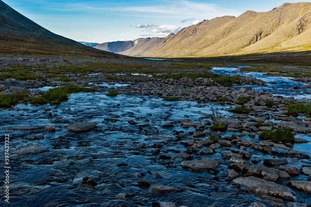 Obraz premium cold stream and mountain range on a summer day