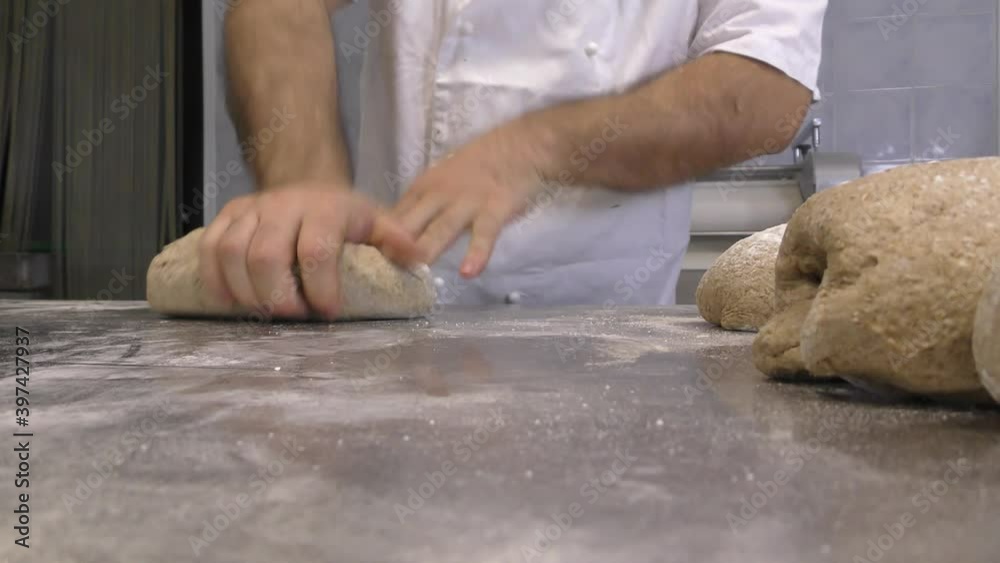 Pane preparato in una panetteria da un fornaio. Panini preparati artigianalmente. Lavoro Pane preparato in una panetteria da un fornaio. Panini preparati artigianalmente. Lavoro