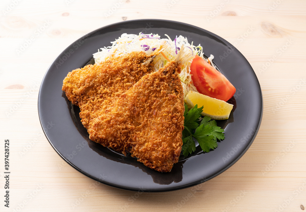 Fried horse mackerel served on a plate on a wooden background