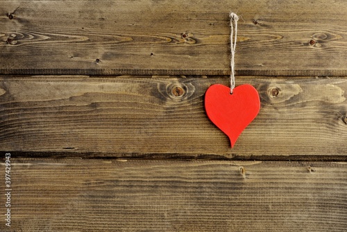 Red heart on a old vintage wooden wall isolated close up. The concept of love and heart warmth.Valentine's Day background