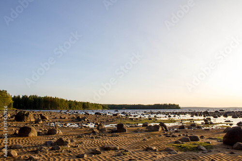 beautiful sunset on lake skagern in sweden, Lake seems like the sea. Many stones and coast full of sand photo