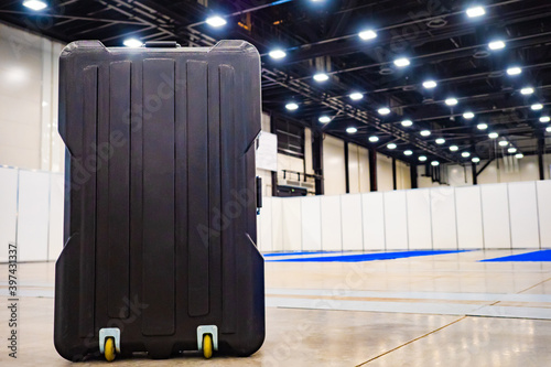 Black plastic suitcase on w...