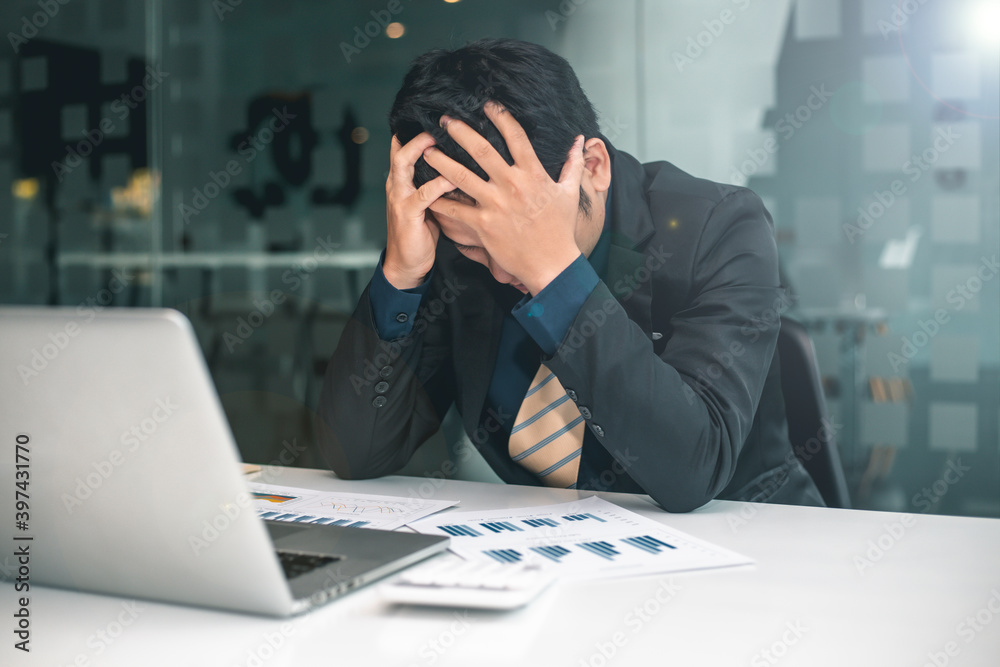 A young Asian male Banchee has a headache as he has been working for hours without rest, Office Syndrome concept. A young Asian male Banchee has a headache as he has been working for hours without rest, Office Syndrome concept.