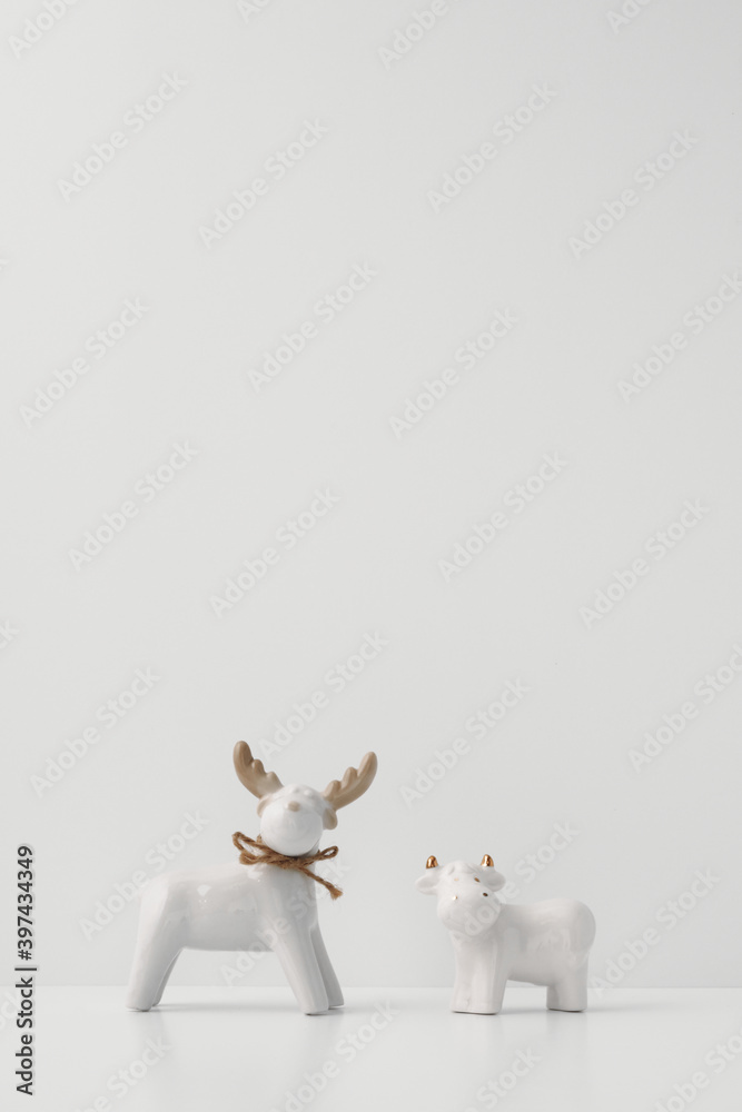 Porcelain figurines of a bull and a deer on a white background. Copy space, mock up Porcelain figurines of a bull and a deer on a white background. Copy space, mock up
