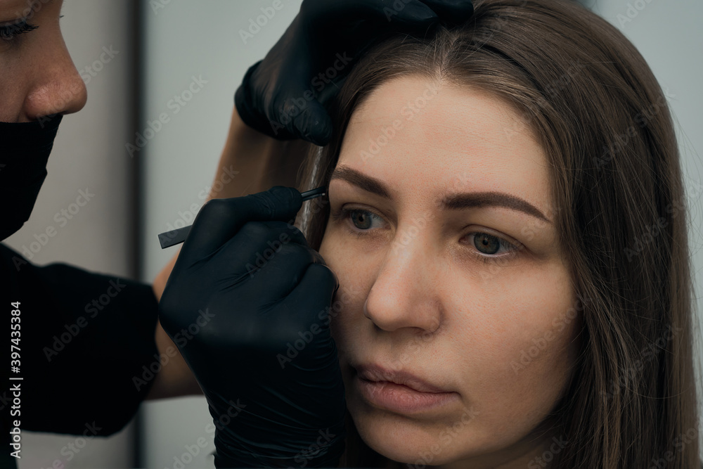 Permanent eyebrow makeup procedure. Eyebrow tattooing, process. The use of tools by a master for permanent eyebrow makeup. Permanent eyebrow makeup procedure. Eyebrow tattooing, process. The use of tools by a master for permanent eyebrow makeup.