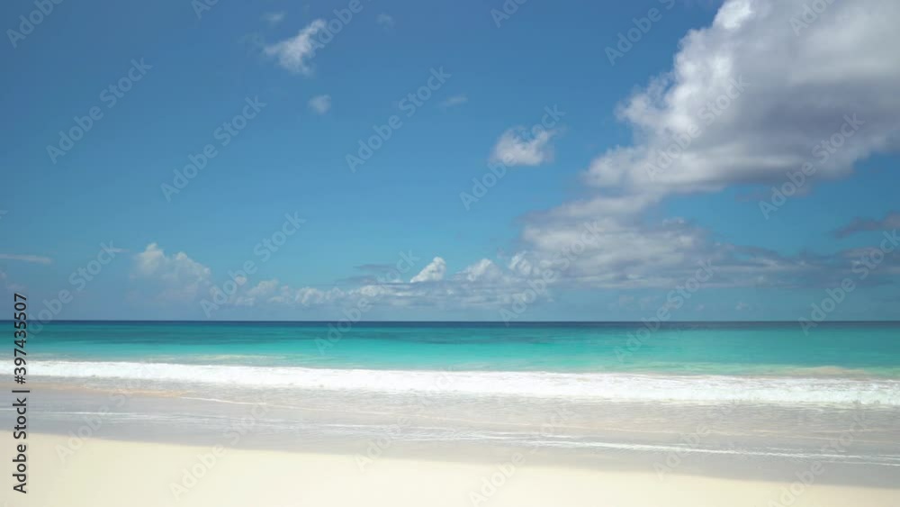 Exotic beach by the ocean with rolling waves on the sandy shore and blue sky Exotic beach by the ocean with rolling waves on the sandy shore and blue sky