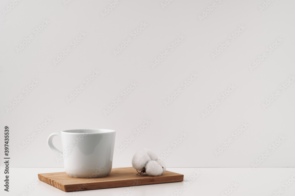 White cup and cotton on a board, cork background. Mock up, copy space. Folk