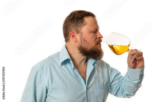 Solid bearded man in shirt tasting whisky studio portrait