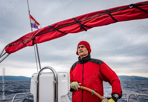 Fotografi An experienced skipper steers the yacht peering into the distance