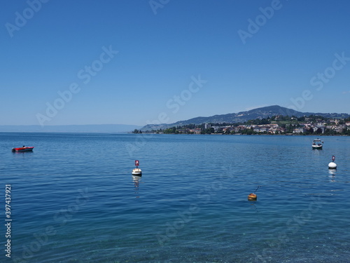 Boats on Lake Geneva and european Montreux city in canton Vaud in Switzerland, clear blue sky in 2017 warm sunny summer day on July.