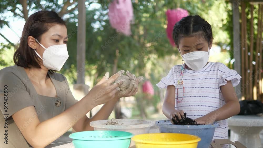 Asian mother and cute daughter doing activities and wearing mask for prevent coronavirus COVID-19 pm 2.5 , family healthy concept. Asian mother and cute daughter doing activities and wearing mask for prevent coronavirus COVID-19 pm 2.5 , family healthy concept.