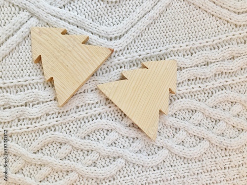 Two wooden Christmas trees on a sweater background. Sweater texture concept. ...
