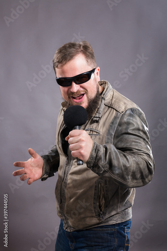 Bearded emotional rock singer with microphone studio portrait. photo