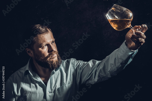 Solid bearded man in shirt with glass of whisky