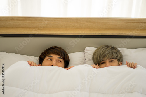 Asian men same sex love marriage LGBTQ on bed during holiday having good time. 