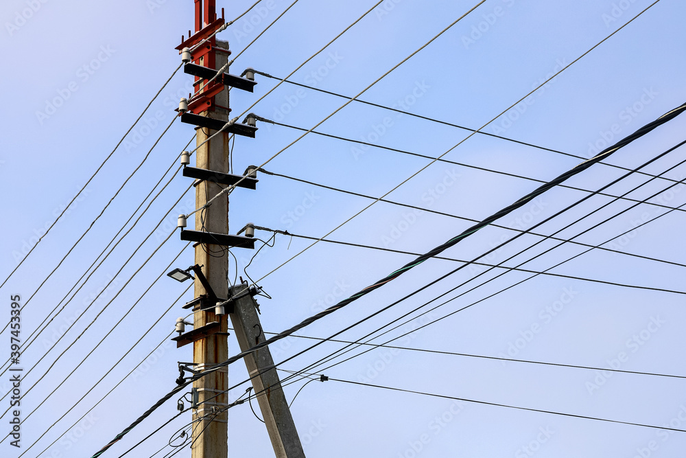 Interlacing electric wires with lights against the sky. Silhouette of a pillar Interlacing electric wires with lights against the sky. Silhouette of a pillar