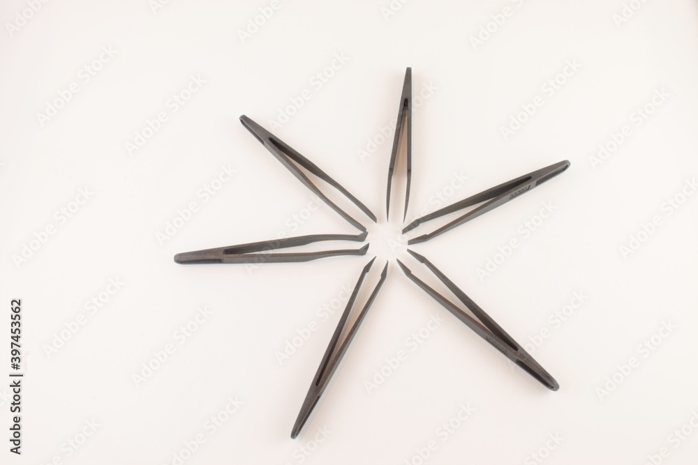 Black plastic tweezers, black star isolated on a white background Black plastic tweezers, black star isolated on a white background