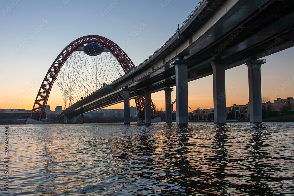 Fototapeta premium A beautiful picturesque bridge in Moscow. Unusual architecture. Bridge on the background of sunset. Bridge over the river. Quiet winter evening