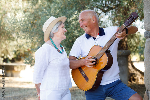 Uomo anziano dedica a sua moglie una canzone d'amore in un contesto naturale photo