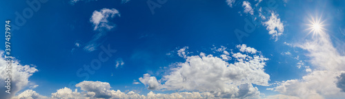 Blue sky with clouds in sunlight  wide cloudscape background panorama