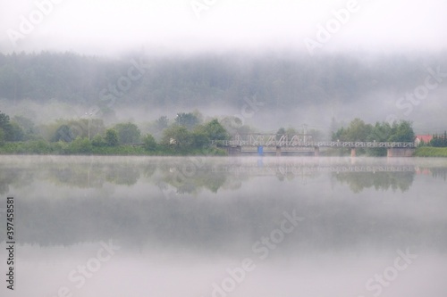 Misty view of Krempna reservoir and bridge on magical morning. Low Beskids Mountains, Poland
